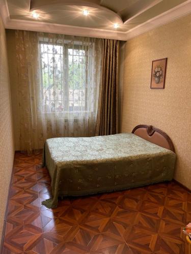 a bedroom with a bed in a room with a window at Sargsyan’s House in Gyumri