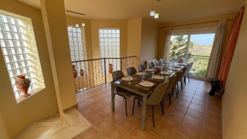 a dining room with a long table and chairs at Villa Clairol in Los Gallardos