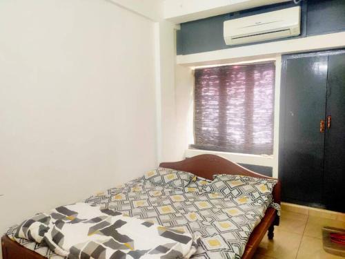 a bedroom with a bed and a window at Good stay service apartments cenotaph road in Chennai