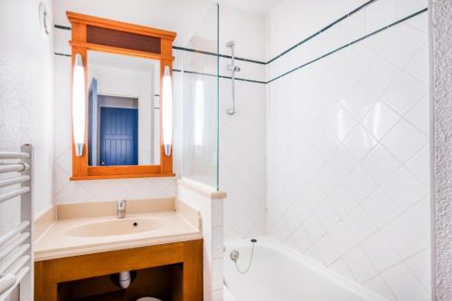une salle de bain avec un lavabo et un miroir dans l'établissement Résidence Lacanau Les Pins - maeva Home - Appartement 2 Pièces 5 Personnes - Sélection MAE-7323, à Lacanau
