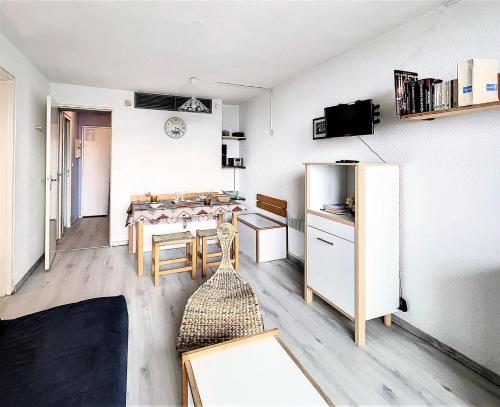 Una sala de estar con una mesa de comedor y una cocina. en Résidence Phenix - STUDIO CABINE 4/5 PERSONNES MAE-9734, en Le Corbier