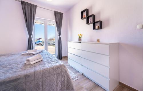 ein weißes Schlafzimmer mit einer Kommode und einem Bett in der Unterkunft 3 Bedroom Amazing Home In Lisane Ostovicke in Lišane Ostrovičke