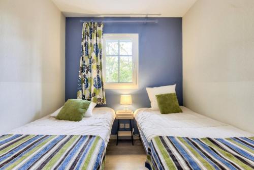 deux lits jumeaux dans une chambre avec fenêtre dans l'établissement Les Maisons de Lacanau les Pins - maeva Home - Maison 3 pièces 6 personnes - Sélection MAE-7336, à Lacanau