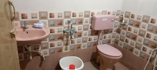 a bathroom with a pink toilet and a sink at AVAR Home syay in Virāmpattinam