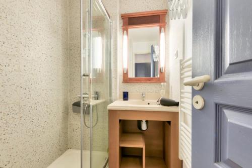 une salle de bain avec un lavabo et une douche en verre dans l'établissement Résidence Lacanau Les Pins - maeva Home - Appartement 2 Pièces 5 Personnes - Prestige MAE-7340, à Lacanau