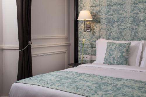 a bedroom with a bed with a green patterned wall at Sanasaryan Han, a Luxury Collection Hotel, Istanbul in Istanbul