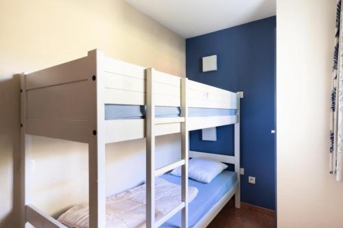 Ce lit superposé se trouve dans un dortoir aux murs bleus. dans l'établissement Résidence Lacanau Les Pins - maeva Home - Studio 5 Personnes - Sélection MAE-7451, à Lacanau