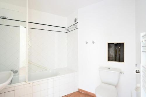 une salle de bain blanche avec des toilettes et un lavabo dans l'établissement Résidence Lacanau Les Pins - maeva Home - Studio 5 Personnes - Sélection MAE-7451, à Lacanau
