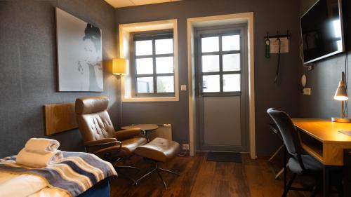 1 dormitorio con 1 cama, escritorio y sillas en Vestnes Fjordhotell en Vestnes