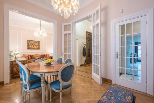 a dining room with a table and blue chairs at Rare Luxury Gem in the Most Elite Area near Syntagma Square in Athens