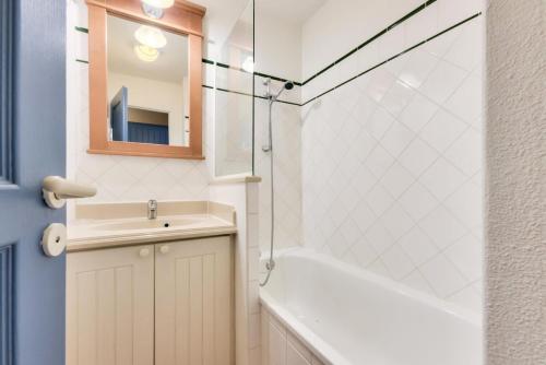 une salle de bain avec un lavabo, une baignoire et un miroir dans l'établissement Résidence Lacanau Les Pins - maeva Home - Appartement 2 Pièces 5 Personnes - Sélection MAE-7592, à Lacanau