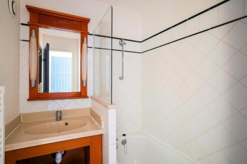 une salle de bain avec un lavabo, une baignoire et un miroir dans l'établissement Résidence Lacanau Les Pins - maeva Home - Appartement 2 Pièces 5 Personnes - Sélection MAE-7738, à Lacanau