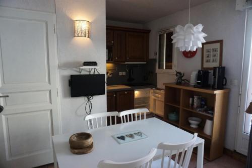 - une cuisine avec une table blanche et des chaises blanches dans l'établissement Chalet D'orcieres - Studio cabine 4 personnes MAE-2754, à Orcières
