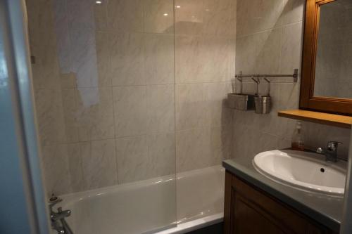 une salle de bain avec une baignoire et un lavabo dans l'établissement Chalet D'orcieres - Studio cabine 4 personnes MAE-2754, à Orcières