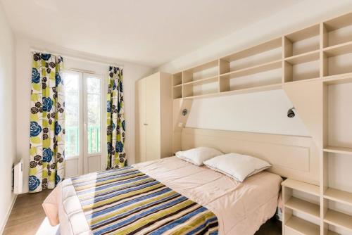 une chambre avec un lit avec des étagères ouvertes dans l'établissement Les Maisons de Lacanau les Pins - maeva Home - Maison 3 pièces 8 personnes - Sélection MAE-7709, à Lacanau