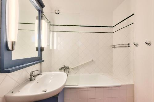 une salle de bain blanche avec un lavabo et une douche dans l'établissement Les Maisons de Lacanau les Pins - maeva Home - Maison 3 pièces 8 personnes - Sélection MAE-7709, à Lacanau