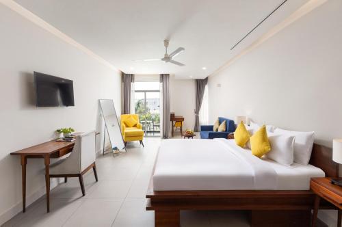 a bedroom with a bed and a desk and a tv at Elysium Suite in Siem Reap