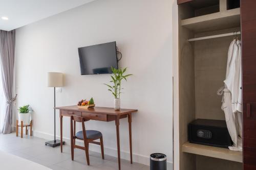 a room with a table and a tv on a wall at Elysium Suite in Siem Reap