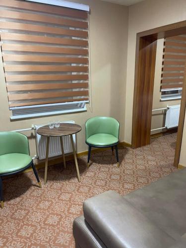Zimmer mit 2 Stühlen, einem Tisch und einem Fenster in der Unterkunft 247 Hotel in Ulaanbaatar