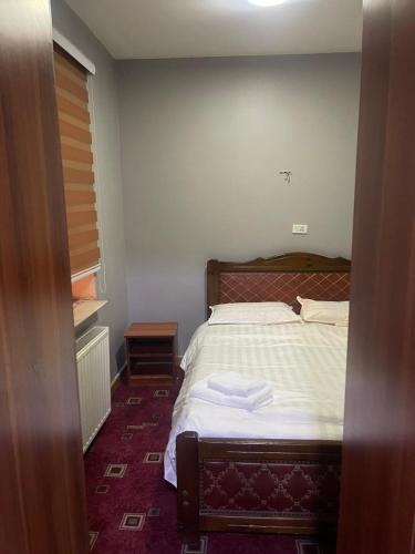 Schlafzimmer mit einem Bett mit weißer Bettwäsche und einem Fenster in der Unterkunft 247 Hotel in Ulaanbaatar