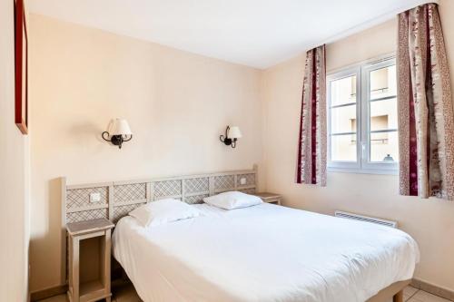 a bedroom with a white bed and a window at Les Coteaux de Pont Royal en Provence - maeva Home - Appartement 2 Pièces 6 Personnes - Sélection MAE-8180 in Mallemort