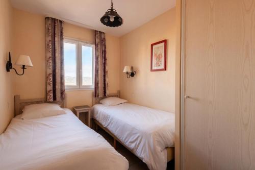 - 2 lits dans une chambre avec fenêtre dans l'établissement Les Coteaux de Pont Royal en Provence - maeva Home - Appartement 3 Pièces 6 81, à Mallemort