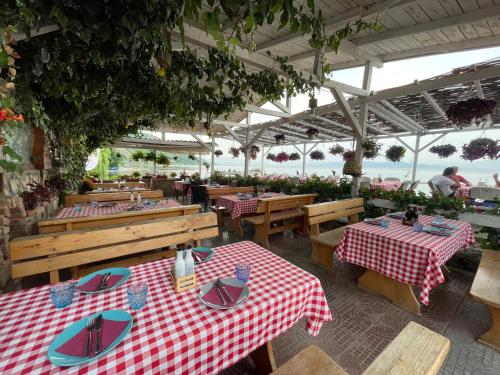 ein Restaurant im Freien mit Tischen und Stühlen und Meerblick in der Unterkunft Villa Radozda in Struga