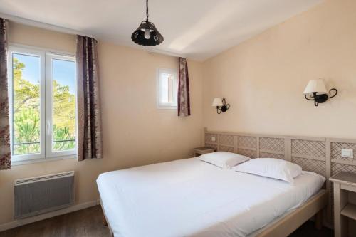 1 dormitorio con cama blanca y ventana en Les Coteaux de Pont Royal en Provence - maeva Home - Maison 3 Pièces 6 Perso 77, en Mallemort