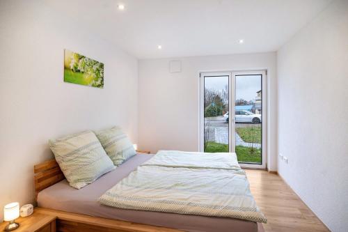 a bedroom with a bed and a large window at Kiefer in Ravensburg