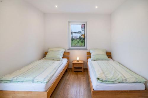 two beds in a room with a window at Kiefer in Ravensburg