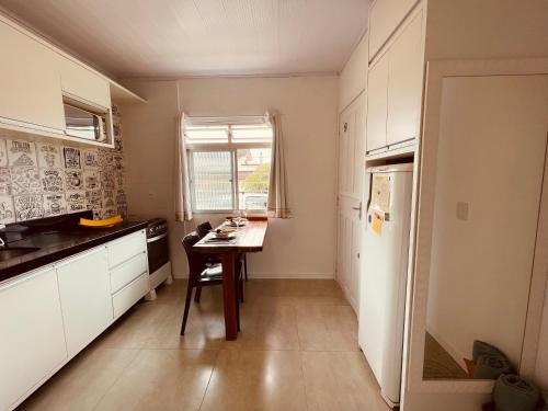 a small kitchen with a table and a window at Loft encantador A - 8 km de Floripa in São José