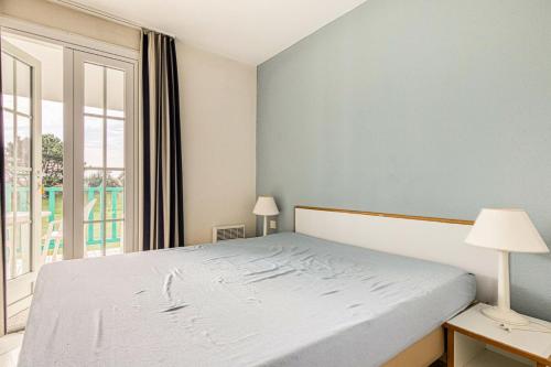 une chambre avec un lit et une grande fenêtre dans l'établissement Résidence Port Bourgenay - maeva Home - Appartement 2 Pièces 7 Personnes - Sélection MAE-8247, à Talmont-Saint-Hilaire