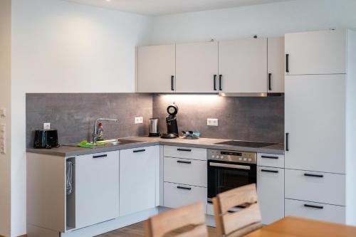 a white kitchen with white cabinets and a sink at Kiefer in Ravensburg