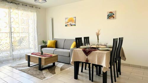 a living room with a table and a couch at Chic & Cozy Living - Near Heart of Paris in Clichy