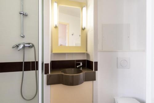 une salle de bain avec un lavabo et un miroir dans l'établissement Résidence le Village de Cap Esterel - maeva Home - Appartement 2 Pièces 6 Personnes - Sélection MAE-8258, à Saint-Raphaël