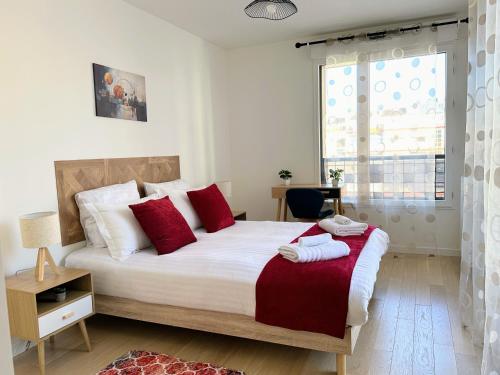 a bedroom with a bed with red pillows and a window at Chic & Cozy Living - Near Heart of Paris in Clichy