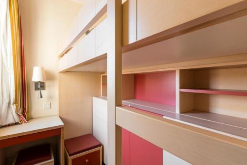 Cette chambre dispose d'étagères rouges et blanches et d'un bureau. dans l'établissement Résidence le Village de Cap Esterel - maeva Home - Studio 4 Personnes - Sélection MAE-8259, à Saint-Raphaël