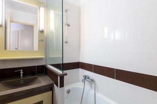 une salle de bain avec un lavabo et une baignoire dans l'établissement Résidence le Village de Cap Esterel - maeva Home - Studio 4 Personnes - Sélection MAE-8259, à Saint-Raphaël