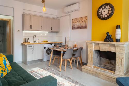 a kitchen and living room with a table and a fireplace at Kostis Orange Resort in Volos