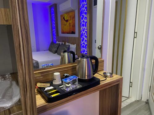 Zimmer mit einem Tisch, einem Wasserkocher und einem Spiegel in der Unterkunft Castle Light Boutique in Alanya