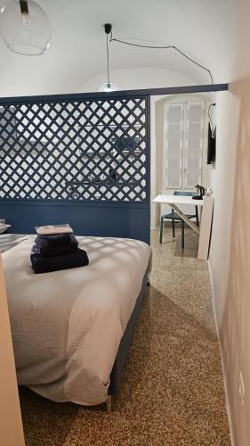 una camera con letto con testiera blu e scrivania di CASA MENOTTI a Sanremo