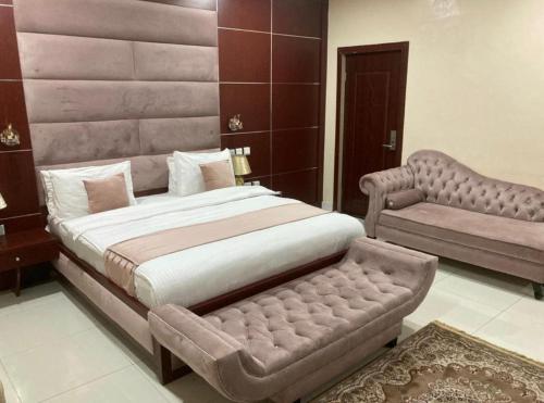 a bedroom with a large bed and a couch at swiss pearl continental hotel in Kano