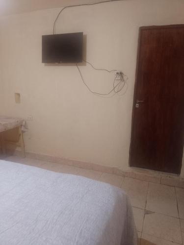 a bedroom with a bed and a tv on the wall at Alojamiento familiar doña justa in Purmamarca