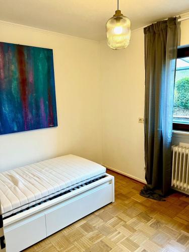 a bed in a room with a painting on the wall at Alex in Pfaffenhausen