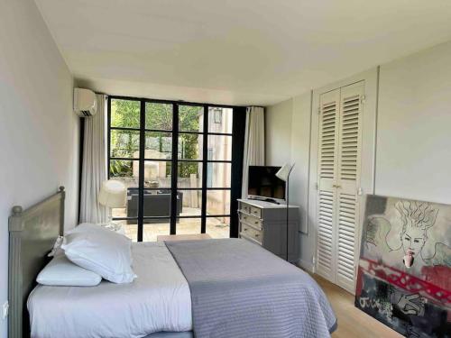 une chambre avec un lit et un bureau avec une télévision dans l'établissement Villa de charme + Loft à 5 min du centre d'Aix, à Aix-en-Provence