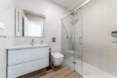 een witte badkamer met een douche en een toilet bij Casa Cayena - Cosy & Trendy apartment near Villa Martin Golf in Orihuela