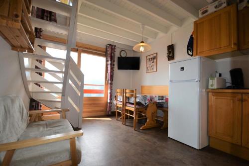 uma cozinha com uma escada e um frigorífico em Résidence La Sapiniere - 4 Pièces pour 5 Personnes 454 em Notre-Dame-de-Bellecombe