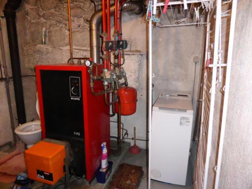 a bathroom with a red boiler and a toilet at Chalet Santa Claus - Chalets pour 8 Personnes 284 in Les Contamines-Montjoie