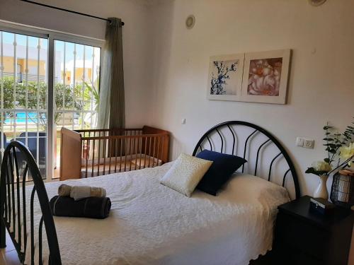 - une chambre avec un grand lit blanc et une fenêtre dans l'établissement Sun & Pool Holiday Apartment, à Albufeira