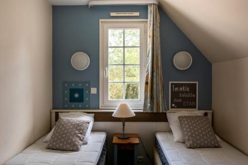 ein Schlafzimmer mit zwei Betten und einem Fenster in der Unterkunft Les Maisons de Belle Dune - maeva Home - Maison 4 Pièces 8 Personnes - Sélection MAE-8641 in Fort-Mahon-Plage